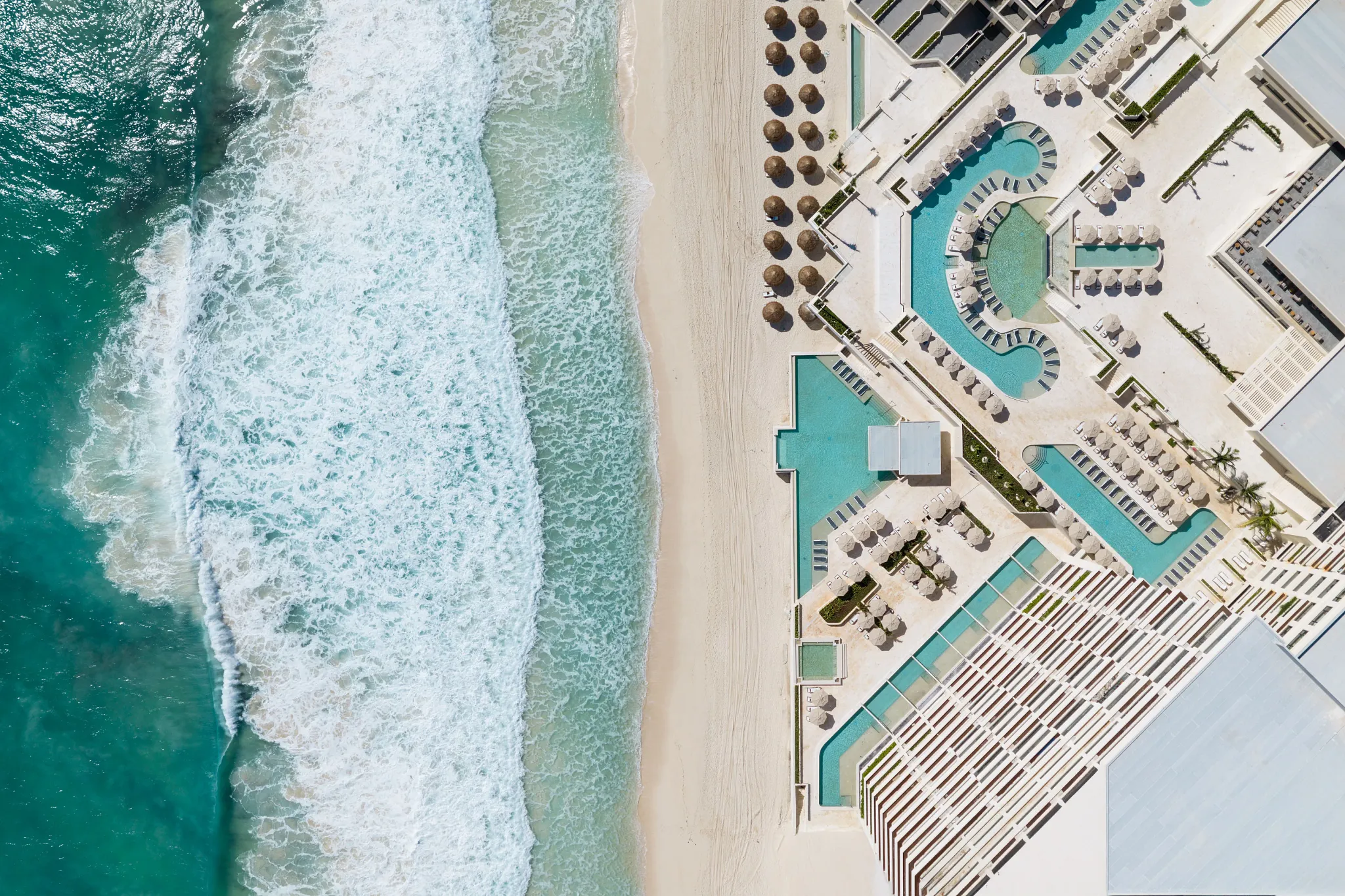 Aerial view of pools and beachfront at Secrets Mirabel Cancun Resort & Spa in Cancun’s Hotel Zone.