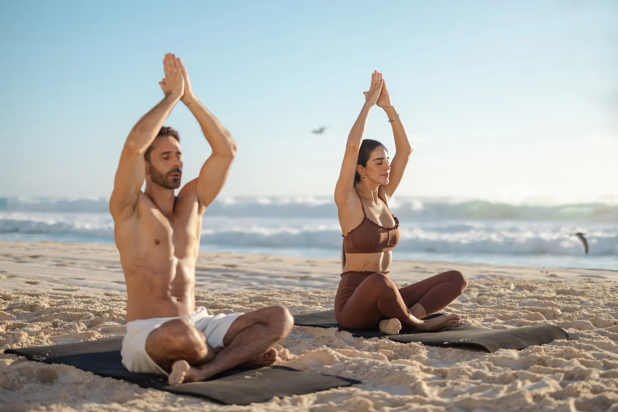 Couple practicing yoga on the beach at Secrets Mirabel Cancun Resort & Spa with ocean views in Cancun.