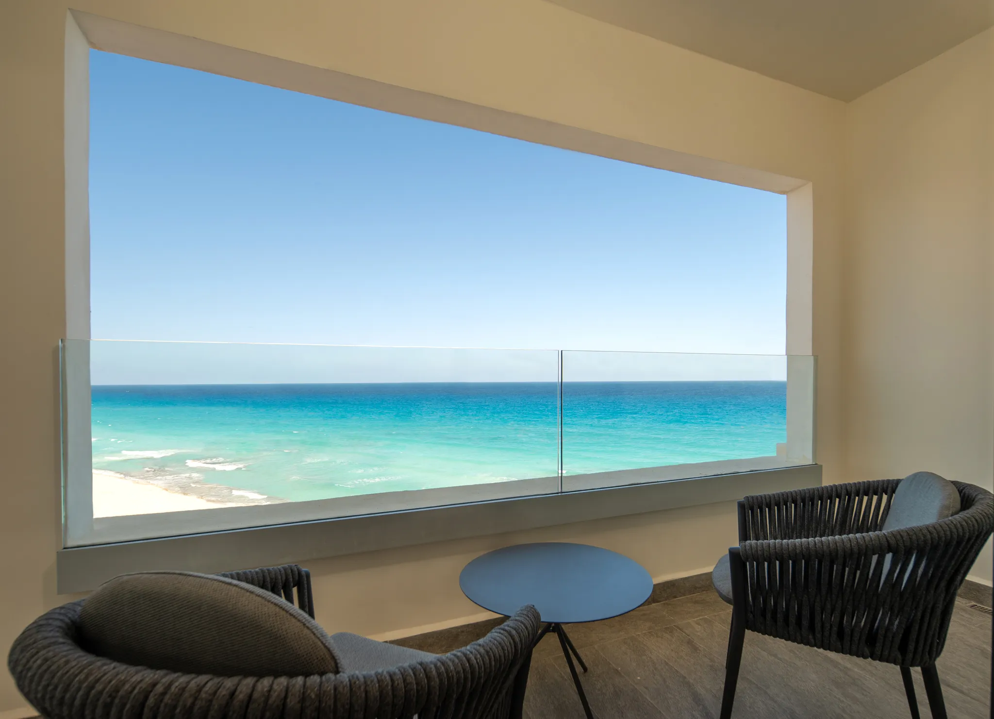 Private furnished balcony with ocean views at Secrets Mirabel Cancun Resort & Spa.