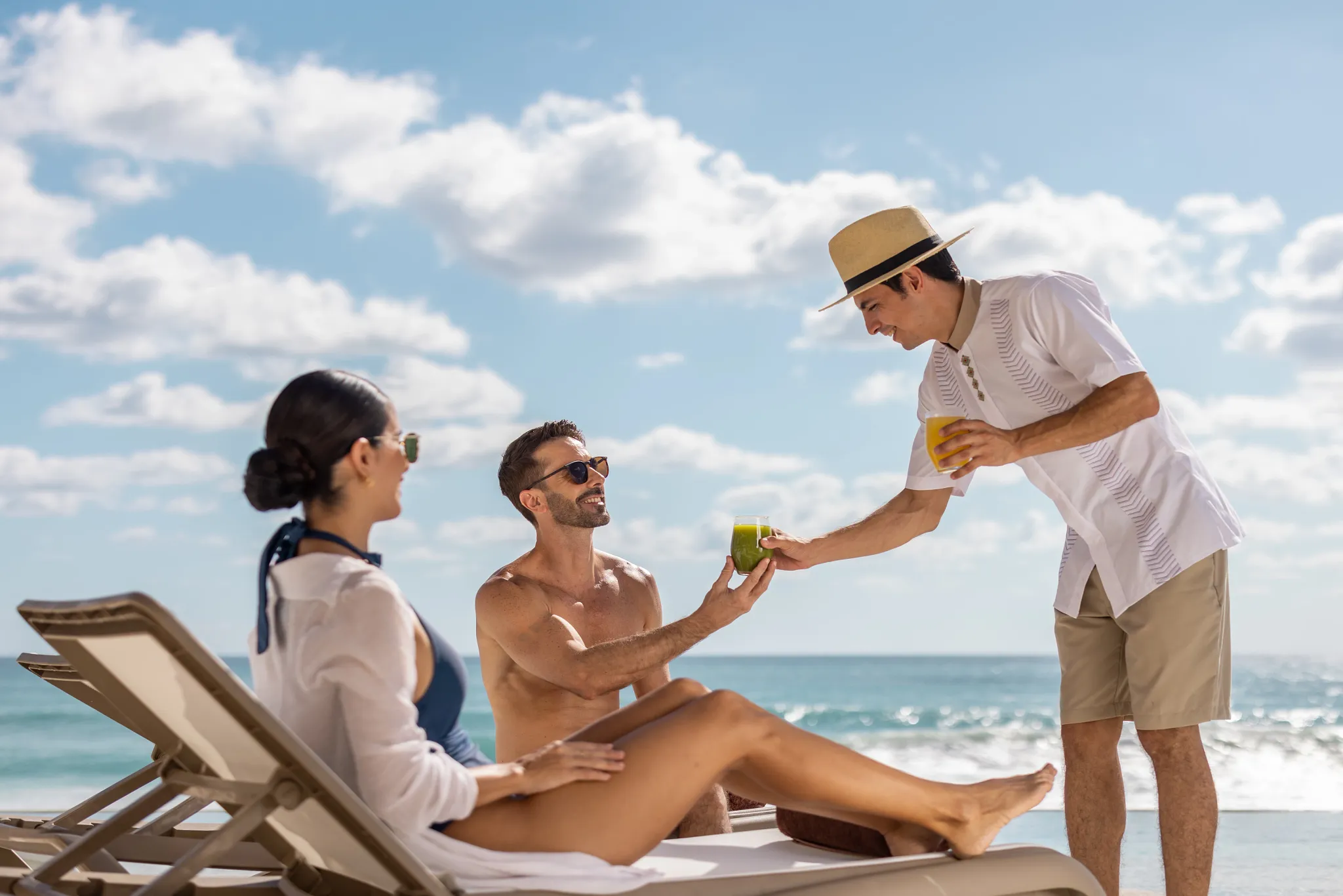 Guests relaxing poolside with fresh drinks and beach service at Secrets Mirabel Cancun Resort & Spa in Cancun.